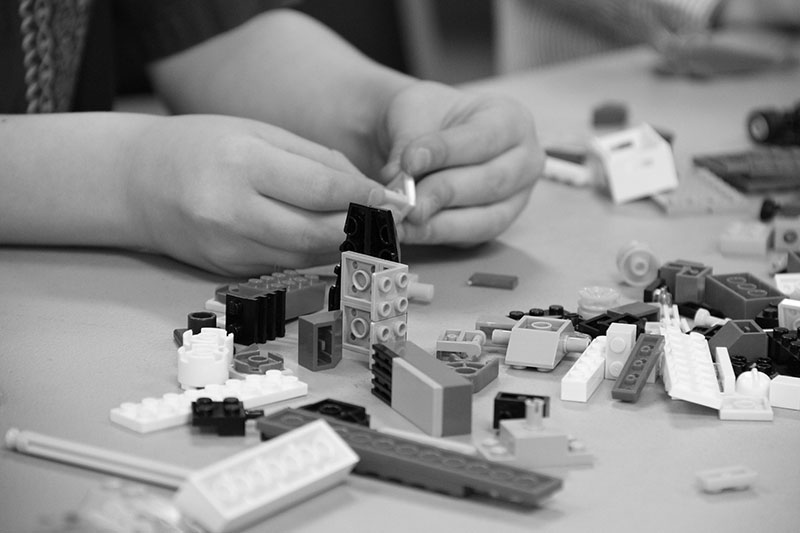 Lego building blocks being assembled on a table.